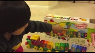 Kid playing with toys Lego Duplo Number Train